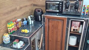 A compact kitchen with a microwave, coffee maker, and a small refrigerator.