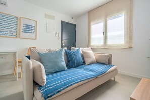 A modern living room with a sofa, cushions, a window, and wall art. - Vacation Apartment 'Isabel 2' with Wi-Fi and Air Conditioning (Guargacho)
