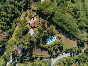 An aerial view of a property with a swimming pool, a house with a tiled roof, and a vineyard. - Villa with Saltwater Pool, Private Garden, and Park in Mugello (Barberino di Mugello)