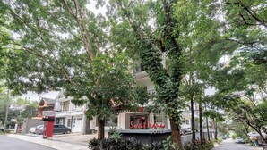 A hotel named 'Sweet Karma' with a signboard, surrounded by lush greenery and trees. - Sweet Karina Hotel Pasteur (Bandung)