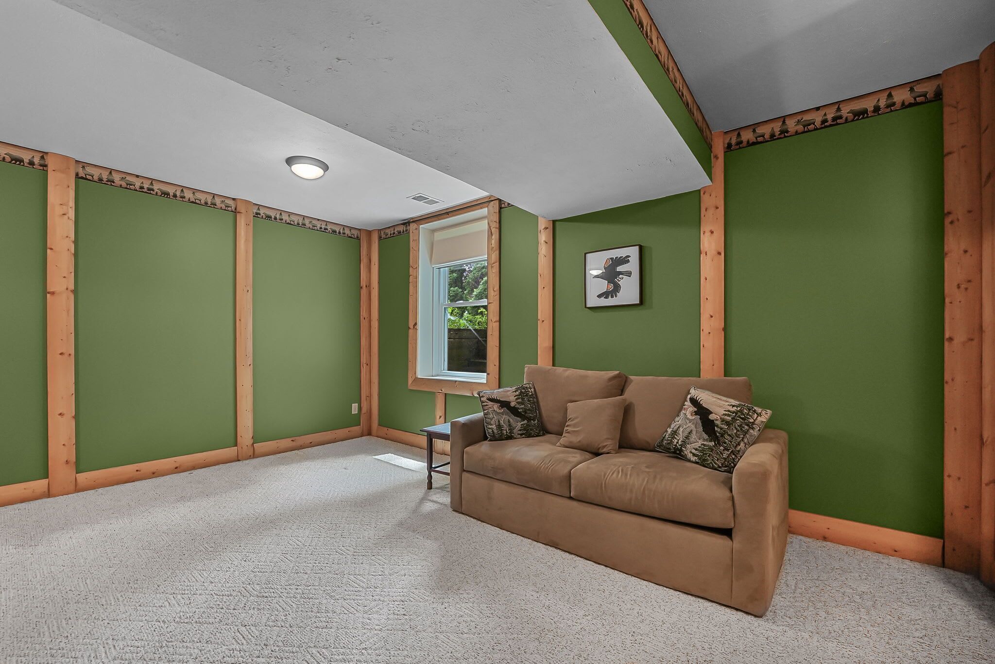 A room with green walls, a brown sofa, and a small table.