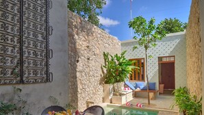 A dining area with a pool, stone walls, and outdoor seating. - Award-winning Casa El Nido in Santa Lucia (Centro)