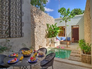 A dining area with a pool, stone walls, and outdoor seating. - Award-winning Casa El Nido in Santa Lucia (Centro)