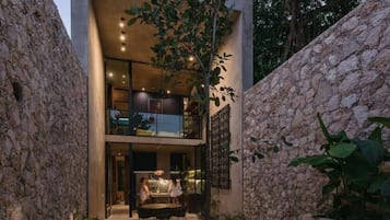 Une terrasse extérieure moderne, dotée d’une piscine, de murs en pierre et d’un espace repas.