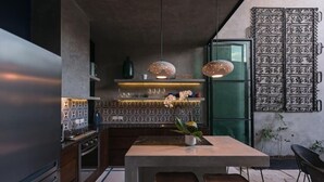 A modern kitchen with a central island, pendant lights, and a decorative metal gate. - Award-winning Casa El Nido in Santa Lucia (Centro)