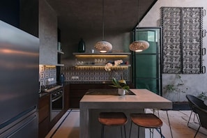 A modern kitchen with a central island, pendant lights, and a decorative metal gate. - Award-winning Casa El Nido in Santa Lucia (Centro)