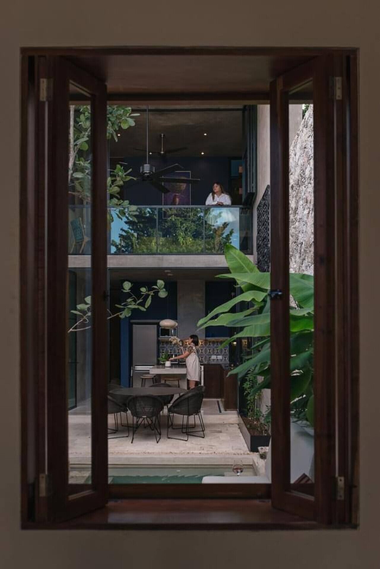 Un intérieur moderne comprenant un espace repas, une cuisine et un balcon agrémenté de plantes.