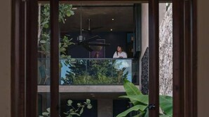 A modern interior with a dining area, a kitchen, and a balcony with greenery. - Award-winning Casa El Nido in Santa Lucia (Centro)