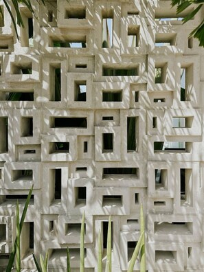Eine Wand mit einem geometrischen Muster aus quadratischen und rechteckigen Öffnungen.