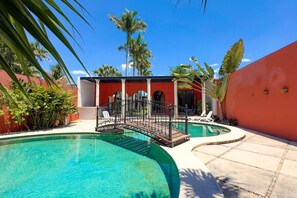 A swimming pool with a bridge, lounge chairs, and a covered area with columns. - Family 3 bdrm Hacienda House in Centro (Centro)