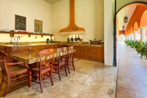 A kitchen with a central island, wooden chairs, and a large oven. - Family 3 bdrm Hacienda House in Centro (Centro)