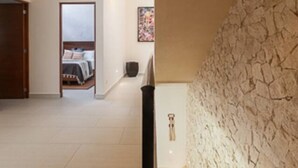 Ein modernes Interieur mit einer Steinwand, einer Treppe und einem Schlafzimmer im Hintergrund.