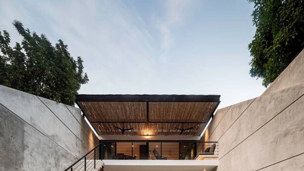 Een modern huis met een zwembad, een trap en een eethoek.