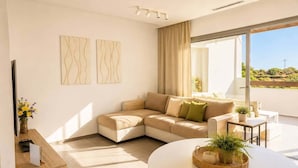 Een moderne woonkamer met een modulaire bank, een ronde tafel en een groot raam met uitzicht.