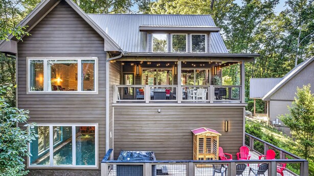 A two-story house with a balcony, a pool, and outdoor seating. - Sevierville Cabin - Pool, Hot Tub, Sauna, Sleeps 14 (Sevierville)