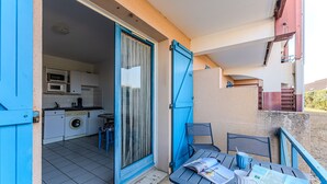 Een balkon met een tafel, stoelen en een tijdschrift.