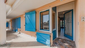 Een gebouw met meerdere blauwe deuren en ramen, een betegelde entree en een bord met het nummer 11.