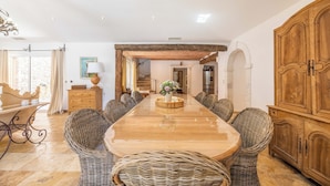 A spacious dining area with a long wooden table, wicker chairs, and a large wooden cabinet. - MASTRU BELLU (BONIFACIO)