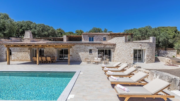 A stone villa with a swimming pool, lounge chairs, and a covered outdoor seating area. - MASTRU BELLU (BONIFACIO)