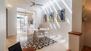 A modern interior with a dining area, ceiling fan, abstract wall art, and a staircase. - Private Pool • Minimal Design • Quiet Stay (Merida)