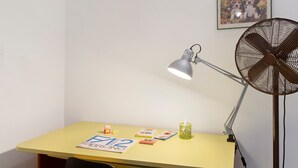 A desk with a lamp, fan, and books. - Iris Holiday Home in Stellanello: Your Peaceful Retreat in Liguria (Rossi)