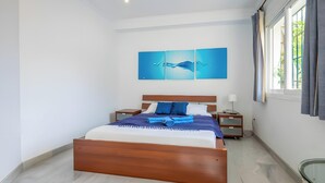 Una camera d'albergo con un letto in legno, un comodino, una lampada e una finestra con tende.