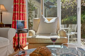 A cozy living area with a sofa, a glass table, a book, and a glass of red wine. - Smithy Cottage -  Beauly , Scottish Highlands, Scotland (Beauly)