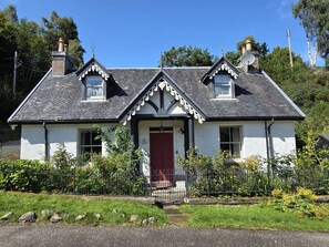 A two-story house with a red door, white walls, and a black roof. - Smithy Cottage -  Beauly , Scottish Highlands, Scotland (Beauly)