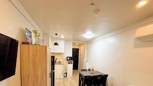 Um espaço compacto com cozinha compacta, área de refeições e um pequeno corredor.