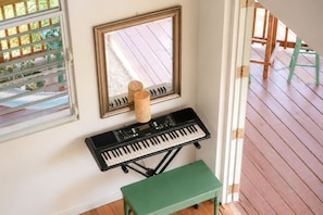 A room with a green bench, a black keyboard, and a window with blinds. - New Mountain Escape Panoramic San Juan Views (Aguas Buenas)