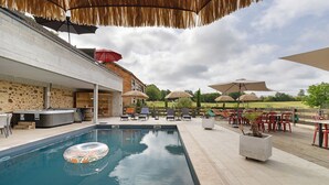 A swimming pool with lounge chairs, umbrellas, and a hot tub area. - Charming Guest Room with Table d’hôtes, Shared Pool, Wi-Fi, and Air Conditioning (Pays-de-Belvès)