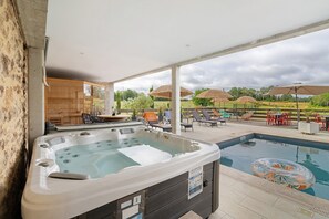 A hot tub, outdoor seating, and a pool area.