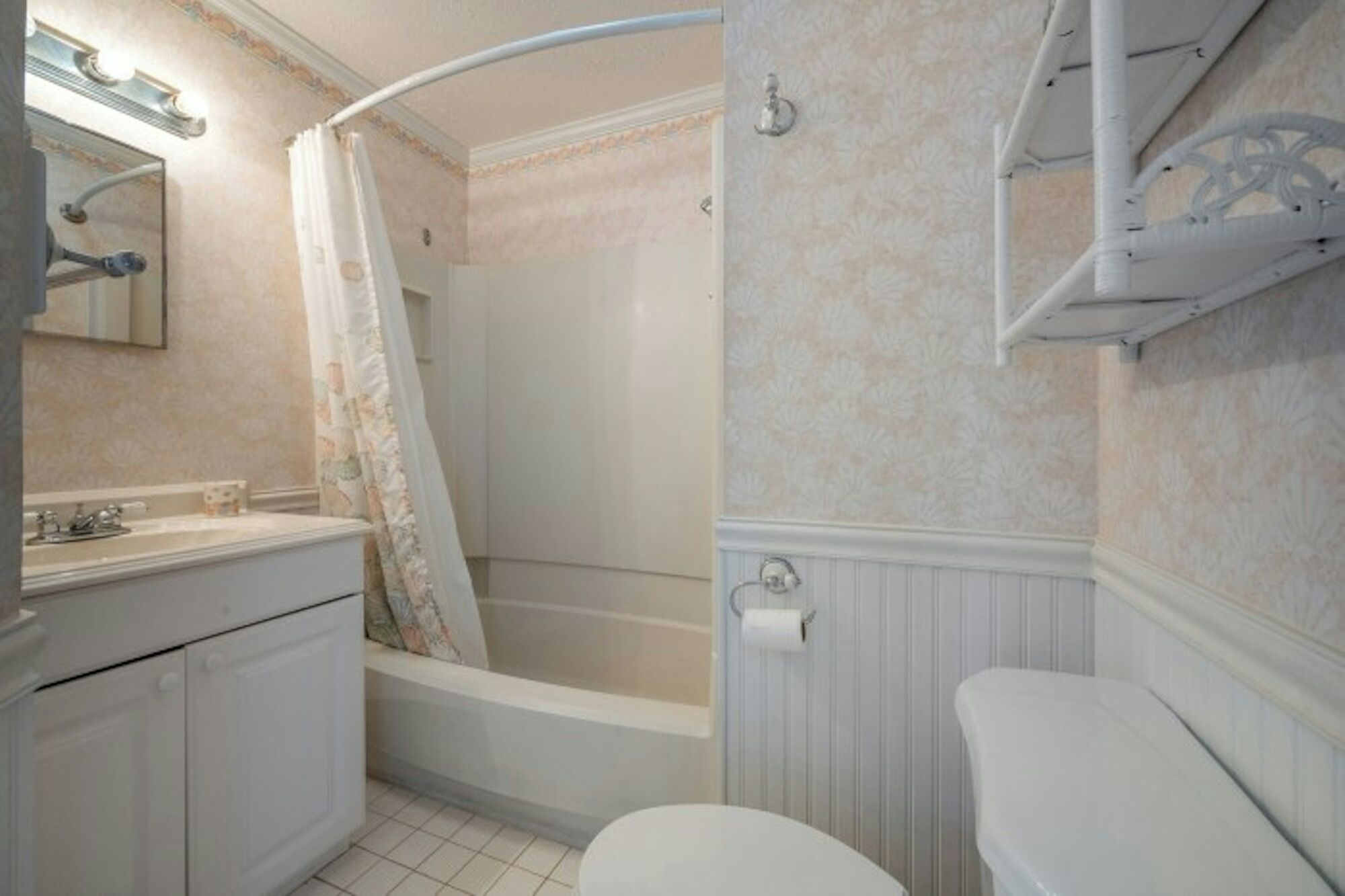 Een badkamer met een bad, toilet en een wastafel met spiegel.