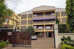 A two-story hotel with a gated entrance, balconies, and a sign indicating the name "Whitley Hotel."