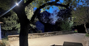 A paved area with a stone wall, trees, and a bench. - A Little Provençal Paradise (Coccinelle Duplex) (Allemagne en Provence)