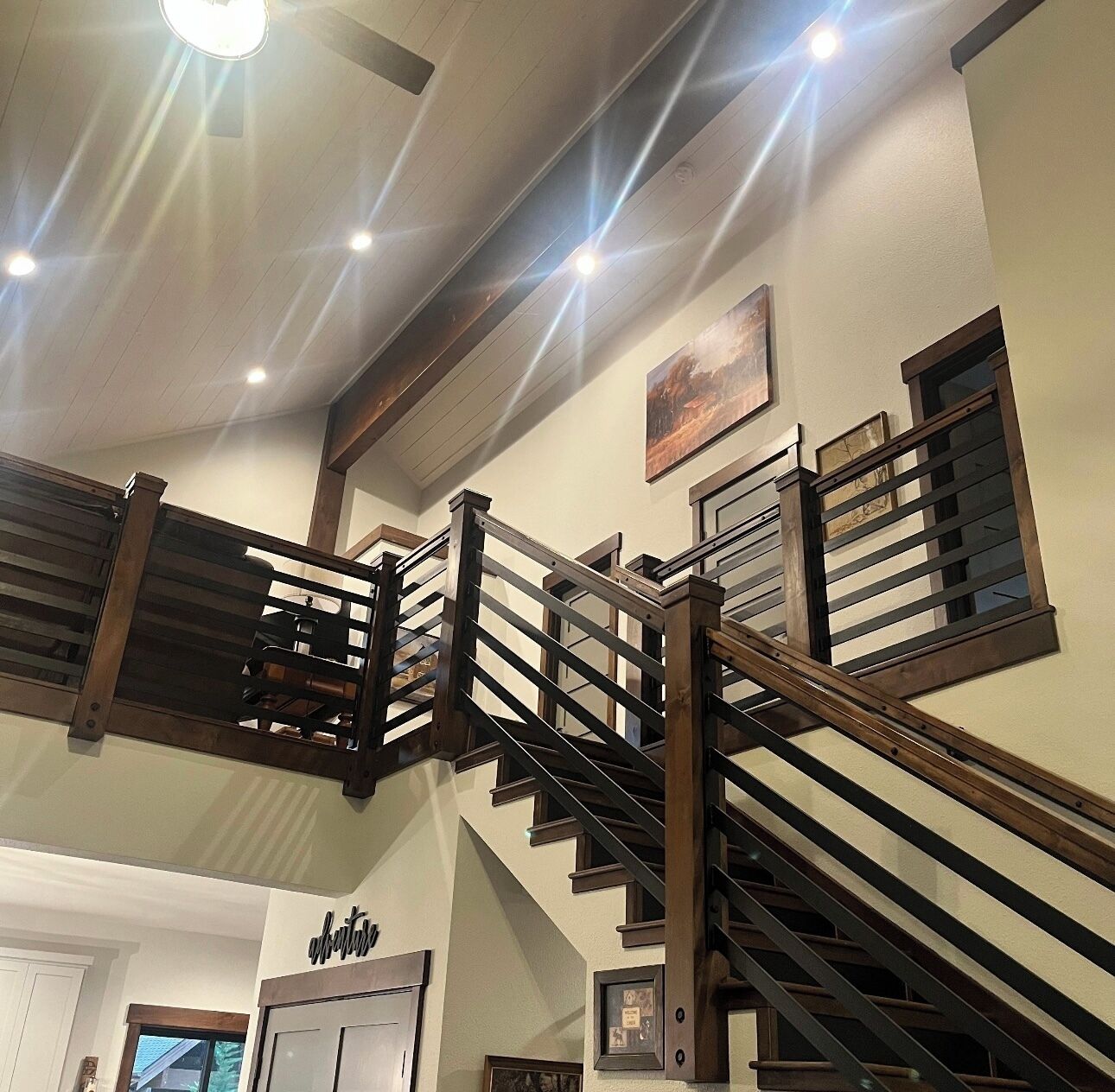 A multi-level interior with wooden staircases and railings, a ceiling light, and a door labeled 'offices'.