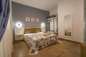 Ein Schlafzimmer mit einem Bett, Nachttischen, einem Spiegel und einem Etagenbett.