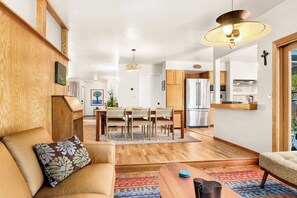 Ein modernes Wohnzimmer mit einer Couch, einem Couchtisch und einem Essbereich mit Stühlen und einem Tisch.