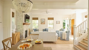 A dining area with a wooden table, chairs, a bowl of fruit, and a chandelier. - Beach Walk, Hot Tub, Pool, Gym, Fire Pit, Games, Sleeps 13 (Lincoln City)