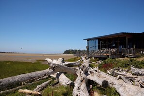 A coastal building with a wooden deck overlooking a beach. - Beach Walk, Hot Tub, Pool, Gym, Fire Pit, Games, Sleeps 13 (Lincoln City)