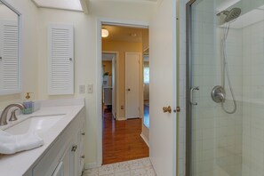 Een badkamer met een wastafel, spiegel en douche.
