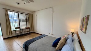 Un dormitorio con cama, escritorio y silla.
