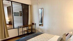 Un dormitorio con cama, escritorio y silla.