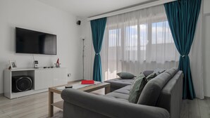 A modern living room with a flat-screen TV, a sofa, a coffee table, and a white entertainment unit. - 2-bedroom apartment in awesome București with AC and comfort (București)