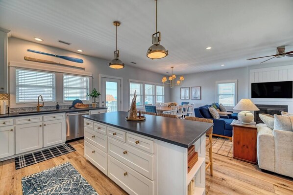 A spacious kitchen with a central island, white cabinetry, and pendant lighting. - Luxury Stay|Free Linens & Baby Items|Walk to Beach|High End Design and Amenities (Surf City)