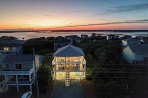 A two-story house with a balcony, surrounded by other houses, overlooking a body of water. - Luxury Stay|Free Linens & Baby Items|Walk to Beach|High End Design and Amenities (Surf City)