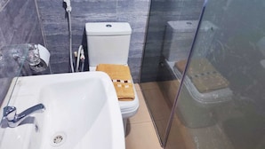 Un baño con lavamanos blanco, inodoro y cabina de ducha.