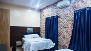 Una habitación de hotel con una cama, un escritorio y una silla.