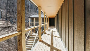 A wooden deck with railings, a staircase, and a view of a forested area. - Double Queen Room near Blue Ridge Tunnel (Waynesboro)