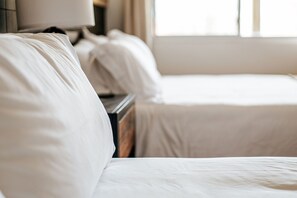 Ein Hotelzimmer mit Bett, Nachttisch und Lampe.